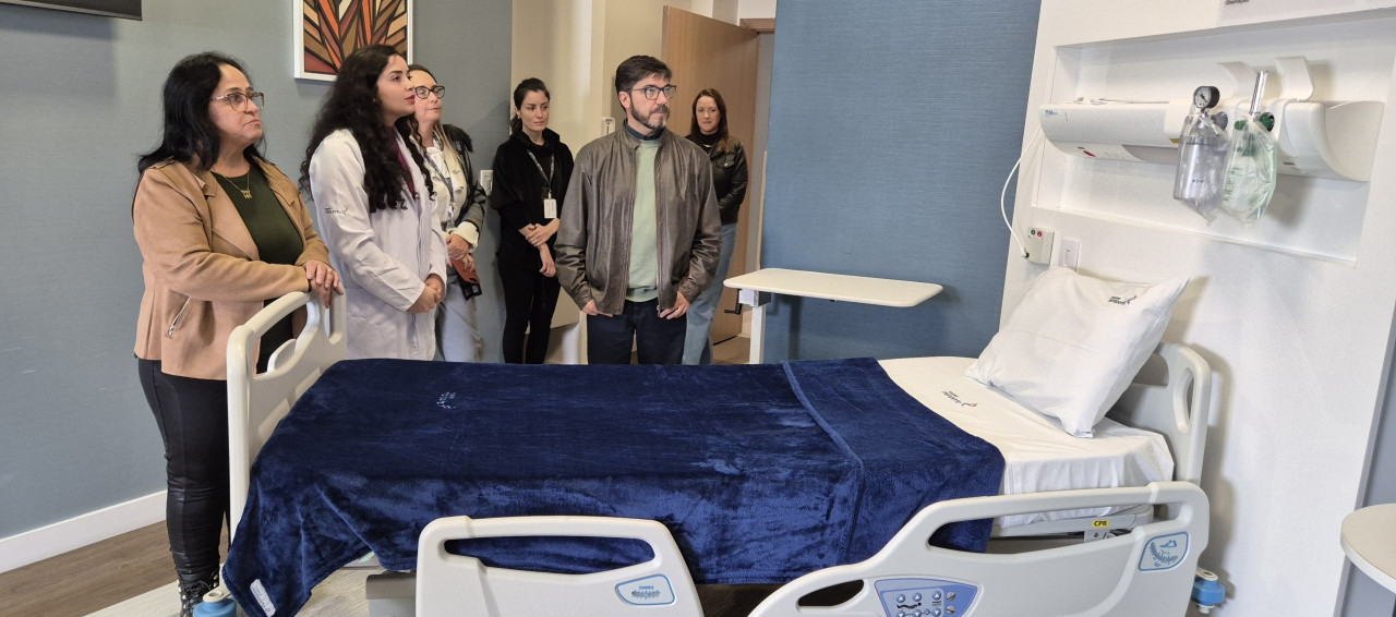 Pessoas dentro de um quarto de hospital verificando as instalações do local