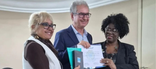 Três pessoas em pé mostrando uma espécie de placa